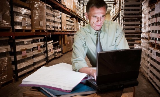 Man in warehouse doing inventory control analysis