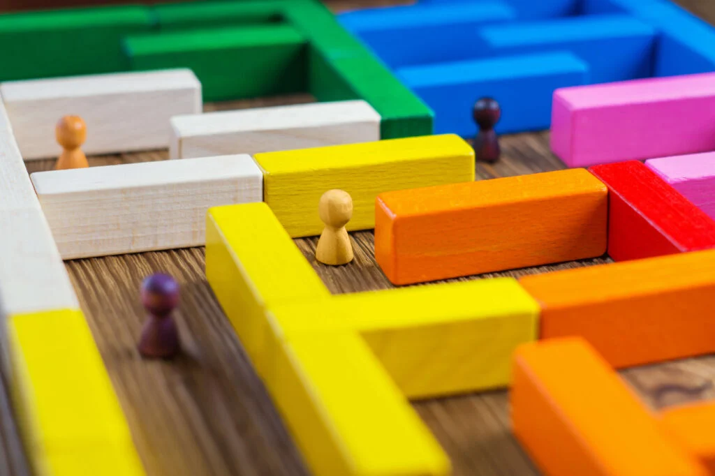 Wooden people counters in a colorful wooden maze 5 demand planning challenges facing distributors today