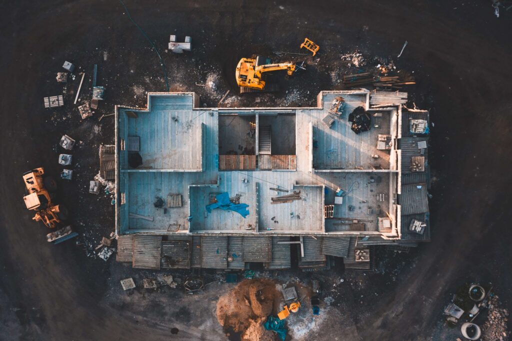 Aerial birds eye image of the frame of a house being built on a construction site at sunset - Wooden floor and walls are visible Building your business in the construction materials industry