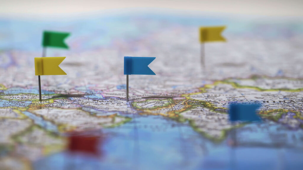 Pins with coloured flags on a world map stretch your supply chain around the globe