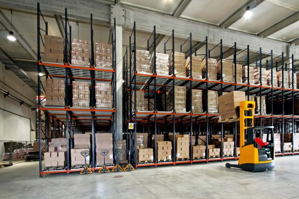 A low loader putting a box on a high shelf in a warehouse 7 ways to boost warehouse productivity