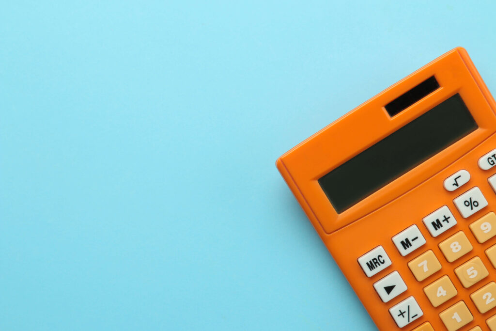 Orange calculator on the corner of a blue background using the economic order quantity formula in inventory management