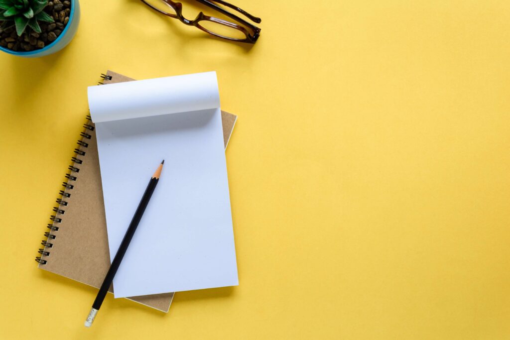 Notebook and pencil on a yellow table Trainingsaanbod