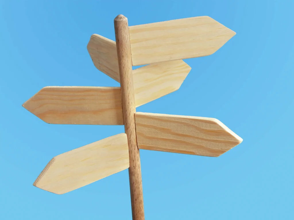 Wooden sign posts on a blue background Distributie software: soorten en mogelijkheden