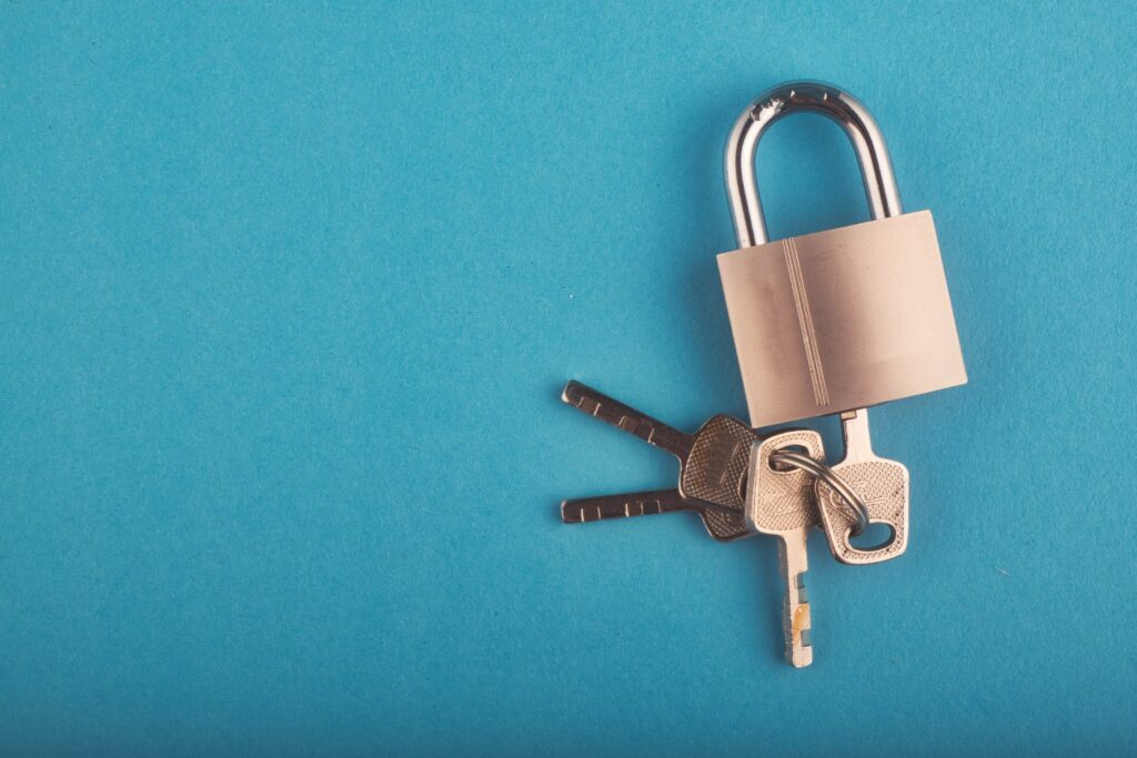 A locked padlock with three keys in on a blue background cyber security