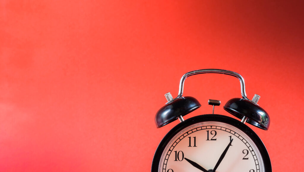 Alarm clock on red background Is er een optimale levertijd?