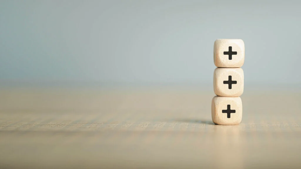 Three wooden blocks stacked on each other with plus signs De voordelen van goed artikelbeheer