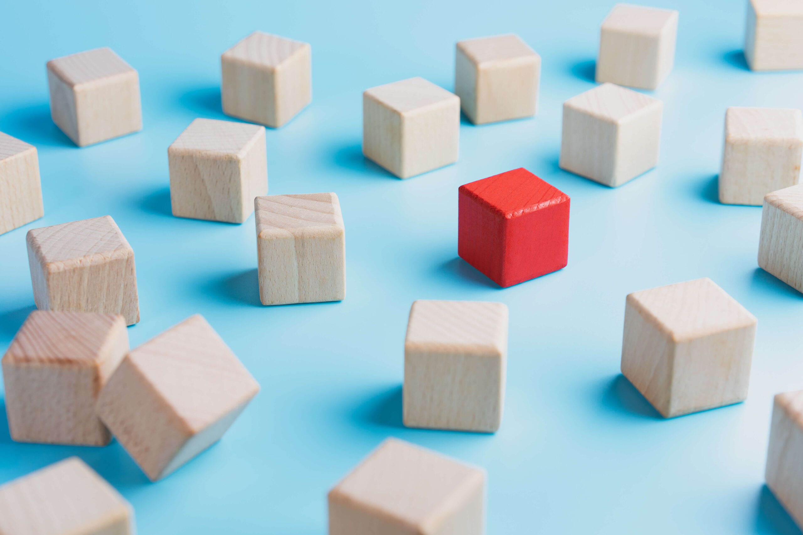 One red wooden box surrounded by colourless wooden blocks on a blue background demand forecasting demand outliers