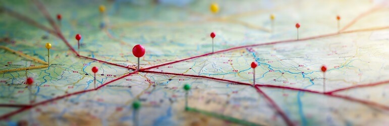 Map with string and pins showing routes. Adventure, discovery, navigation, communication, logistics, geography, transport and travel theme concept background.