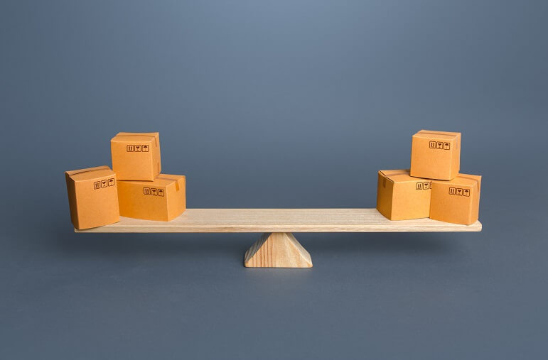 Boxes balancing on a piece of wood on Waarom voorraadmanagers moeten weten voorraadwaarde is 