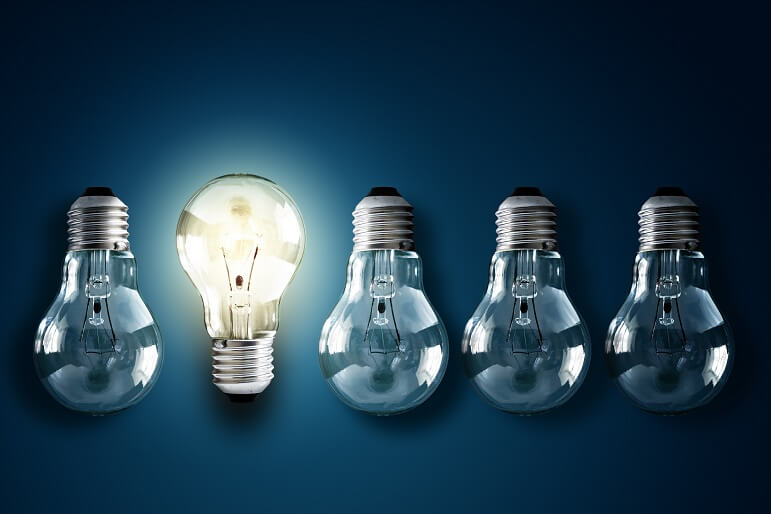 Five lightbulbs with one facing the right way and lit up, the other four facing down and off on a dark background Wat is de beste methode voor voorraadwaardering?