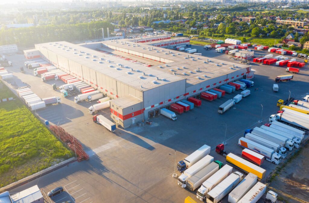 Aerial shot of a large distribution centre with lorries at gates on each side blanket purchase ordering temporary warehouses red sea supply chain disruption