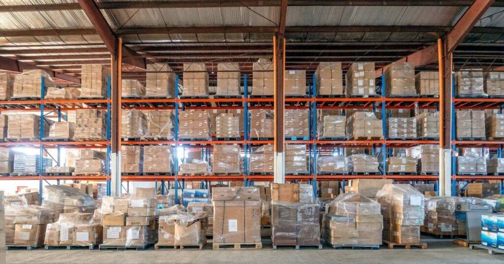 Stort lager med höga hyllställ fyllda med varor, exempel på höga lagernivåer.