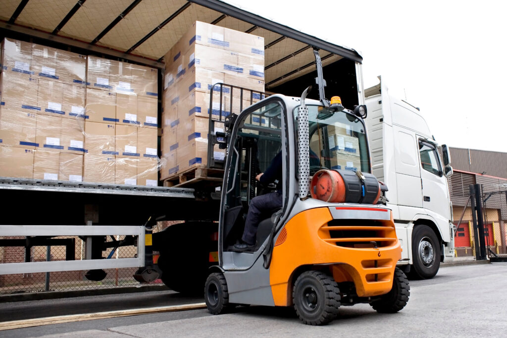 Forklift unloading pallets of boxes from the side of a lorry inventory control techniques
