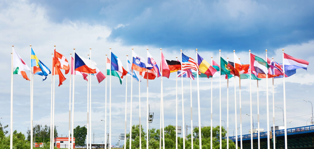 Flags from different countries on flag poles blowing in the wind.
Multishoring can provide access to a broad talent pool offering diverse skills sets. 